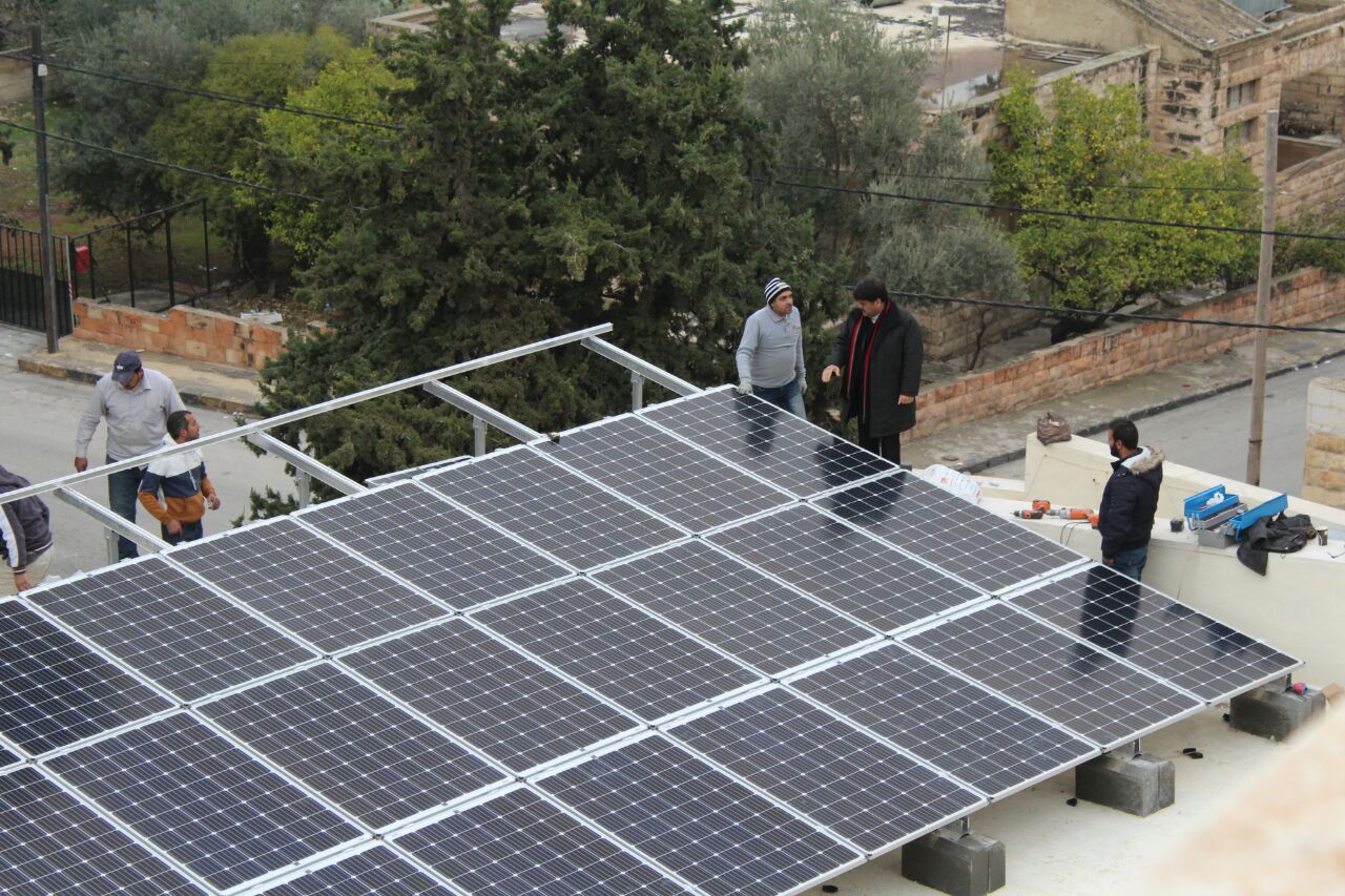 Pfarrer Samir Esaid bei den Arbeitern auf dem Dach der Kirche.